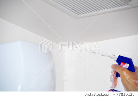 A foamy liquid dripping down the wall surface by repeatedly spraying the mold remover toward the corner of the bathroom ceiling. A foamy liquid dripping down the wall surface by repeatedly spraying the mold remover toward the corner of the bathroom ceiling. 77830123