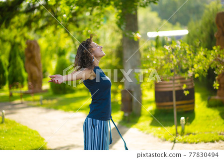 Portrait of young beautiful brunette enjoy bright summer day in green park Portrait of young beautiful brunette enjoy bright summer day in green park 77830494