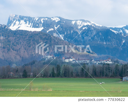 Historic town and Chateau de Gruyeres, Switzerland, in front of the mountains 77830622