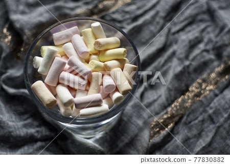 Different coloured marshmellows laying on the table and waiting for their time use. Different coloured marshmellows laying on the table and waiting for their time use. 77830882