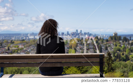 Adult Middle Age Woman sitting outside in a park 77833128
