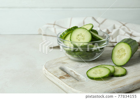 Concept of ripe vegetable with cucumbers on white textured table Concept of ripe vegetable with cucumbers on white textured table 77834155