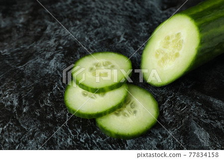 Ripe cucumber and slices on black smoky background 77834158