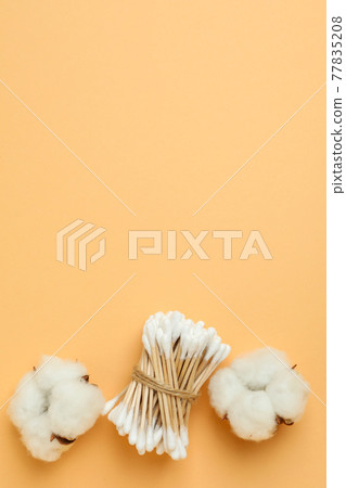Cotton swabs and cotton on beige background Cotton swabs and cotton on beige background 77835208