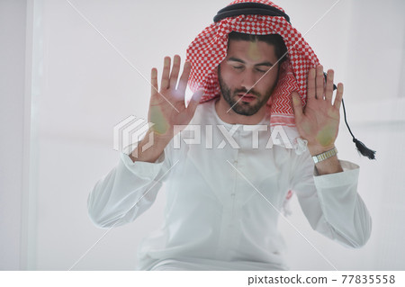 Muslim man doing sujud or sajdah on the glass floor 77835558