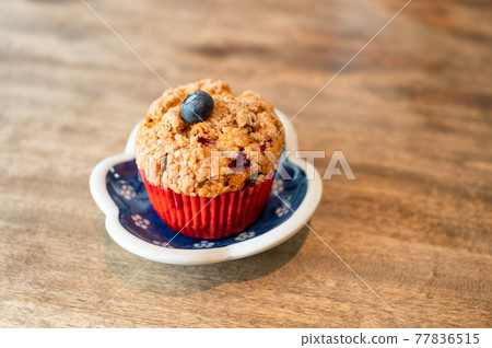 Homemade baked blueberry muffin on wooden table 77836515
