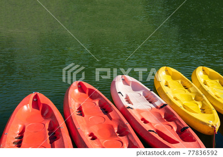 Colorful canoe anchored at pier in lake Colorful canoe anchored at pier in lake 77836592