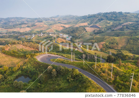 Scenery of Curved asphalt road with electric pole on green hill in countryside Scenery of Curved asphalt road with electric pole on green hill in countryside 77836846