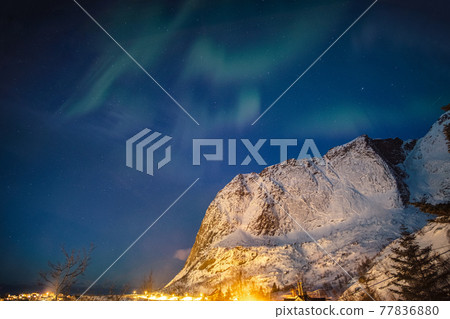 Aurora borealis over snow mountain in Reine town at Lofoten Islands 77836880