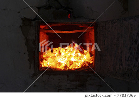 The fire in the furnace. Ember and fire close up. Coals, flames, heat, comfort, relax concept background. 77837369