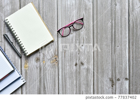 Still life, business office supplies or education concept, Top view image of open notebook and various colorful pencil and eyeglasses with blank pages on old brown wooden, ready for adding text 77837402