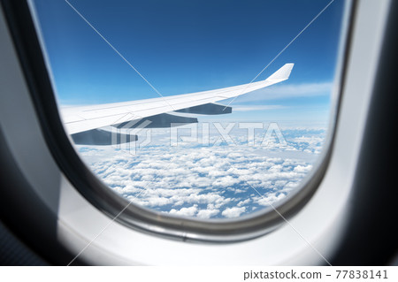 View of clouds and wing from a plane window View of clouds and wing from a plane window 77838141