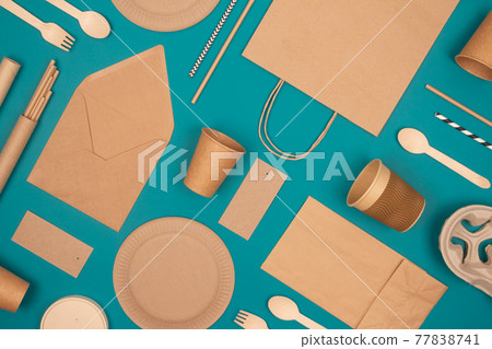 Flat lay with eco-friendly tableware - kraft paper food packaging on green background. Street food paper packaging, recyclable paperware, zero waste packaging concept. Mockup, selective focus 77838741