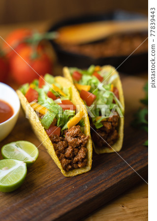 hard shell taco on wooden board with lime hard shell taco on wooden board with lime 77839443