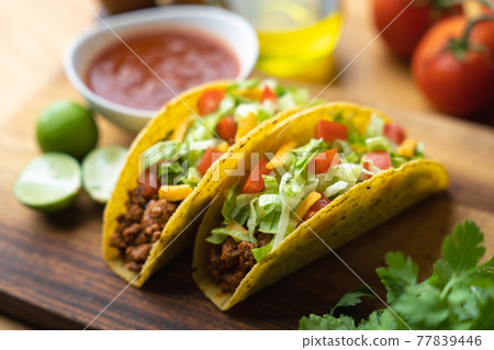 hard shell taco on wooden board with lime 77839446