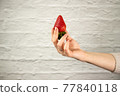 Ripe juicy red beautiful strawberry close-up is an appetizing fresh snack 77840118