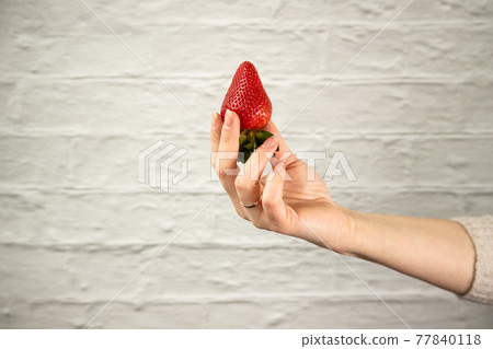 Ripe juicy red beautiful strawberry close-up is an appetizing fresh snack Ripe juicy red beautiful strawberry close-up is an appetizing fresh snack 77840118