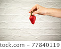 Ripe juicy red beautiful strawberry close-up is an appetizing fresh snack 77840119