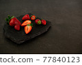 Ripe juicy red beautiful strawberry close-up is an appetizing fresh snack 77840123