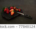 Ripe juicy red beautiful strawberry close-up is an appetizing fresh snack 77840124