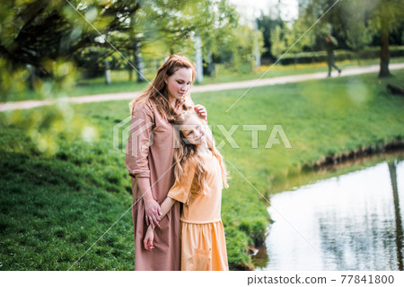 happy family on the bank near the river in summer in the park. Concept of family vacation in nature. mom and kids, mother's day 77841800