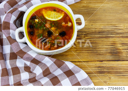 Traditional russian hodgepodge soup on a wooden table. Top view 77846915