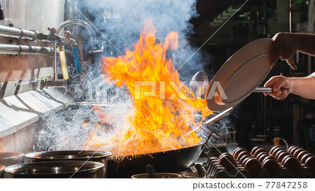 Chef stir fry busy cooking in kitchen Chef stir fry busy cooking in kitchen 77847258