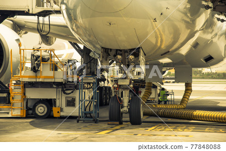 Airplane near the terminal in an airport. 77848088