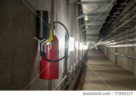 Fire extinguisher in dimly lit corridor Fire extinguisher in dimly lit corridor 77848127