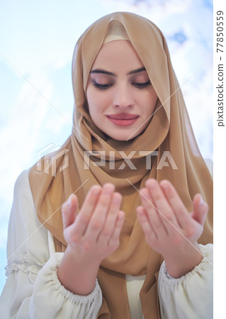 Portrait of young muslim woman praying or making dua to God Portrait of young muslim woman praying or making dua to God 77850559