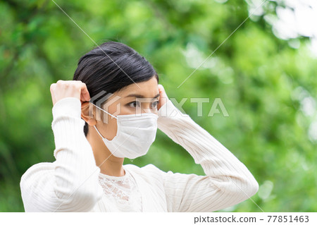 Fresh greenery and a business woman wearing a mask 77851463