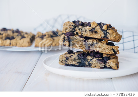 Oat blueberry scones on white wooden background. Vegan pastry. 77852439