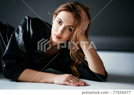 Trendy sexy young woman in black cloth posing over studio background 77856077