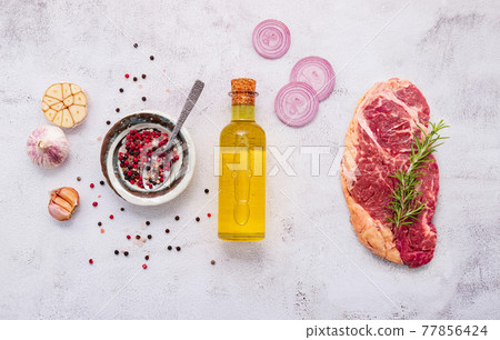 Raw Striplion Steak set up on white concrete background. Flat Lay of fresh raw beef steak with rosemary and spice on white shabby concrete background top view. Raw Striplion Steak set up on white concrete background. Flat Lay of fresh raw beef steak with rosemary and spice on white shabby concrete background top view. 77856424
