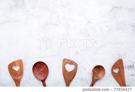 Various heart shape of wooden cooking utensils. Wooden spoons and wooden spatula on white concrete background with flat lay and copy space. Various heart shape of wooden cooking utensils. Wooden spoons and wooden spatula on white concrete background with flat lay and copy space. 77856427