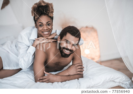 Wife and husband having rest together on bed 77856940