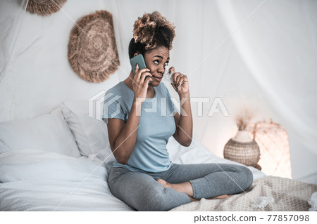 African American woman with smartphone and napkin near eyes African American woman with smartphone and napkin near eyes 77857098
