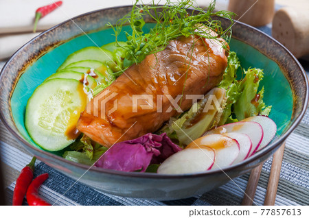 baked fish with cucumbers and radishes and herbs. Asian cuisine 77857613