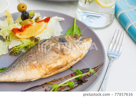 grilled Dorado with lettuce, lemon and olives grilled Dorado with lettuce, lemon and olives 77857616