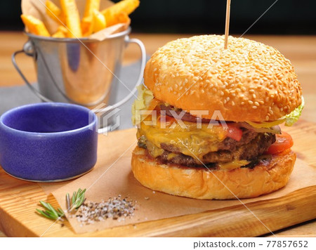 Burger with two juicy beef patties and cheese, with French fries 77857652