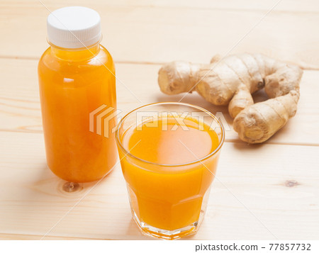 sea buckthorn lemonade in a bottle and in a glass. Concept: food delivery sea buckthorn lemonade in a bottle and in a glass. Concept: food delivery 77857732