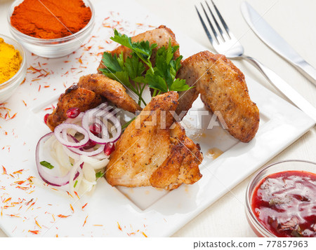 grilled chicken wings on a white plate with pickled onions grilled chicken wings on a white plate with pickled onions 77857963