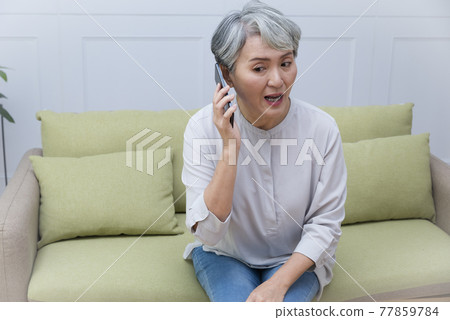 一位銀髮族年長婦女講手機電話,享受悠閒自在的生活 77859784