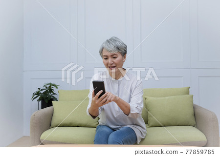 An elderly woman with silver hair talks on her mobile phone and enjoys a leisurely life An elderly woman with silver hair talks on her mobile phone and enjoys a leisurely life 77859785