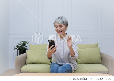 An elderly woman with silver hair talks on her mobile phone and enjoys a leisurely life An elderly woman with silver hair talks on her mobile phone and enjoys a leisurely life 77859790