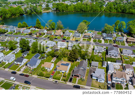 Wide panorama, aerial view with tall single home, in the beautiful residential quarters Sayreville town near pond New Jersey US 77860452
