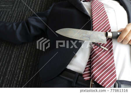 A businessman with a kitchen knife A businessman with a kitchen knife 77861316