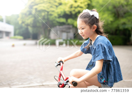 A girl riding a bicycle A girl riding a bicycle 77861359