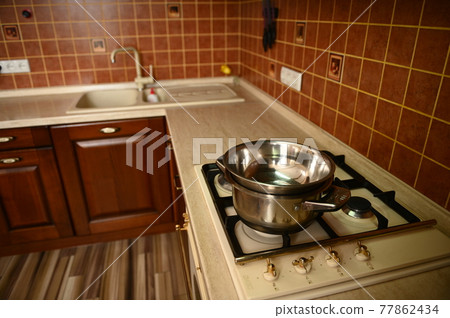 Interior of a wooden kitchen with a water bath on an electric stove Interior of a wooden kitchen with a water bath on an electric stove 77862434