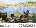 Asian female tourists camping and And working notebook, She is happy, relaxed, enjoying reading a book. 77862621